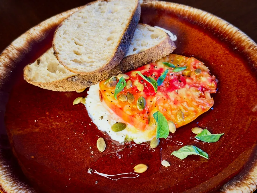 Heirloom tomato with whipped chèvre, basil, pepitas, olive oil, and country bread