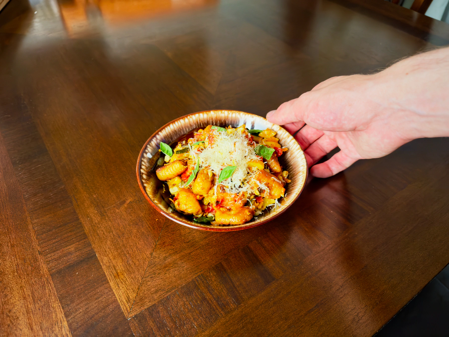 Ricotta gnocchi with sweet corn and summer squash presented at the table